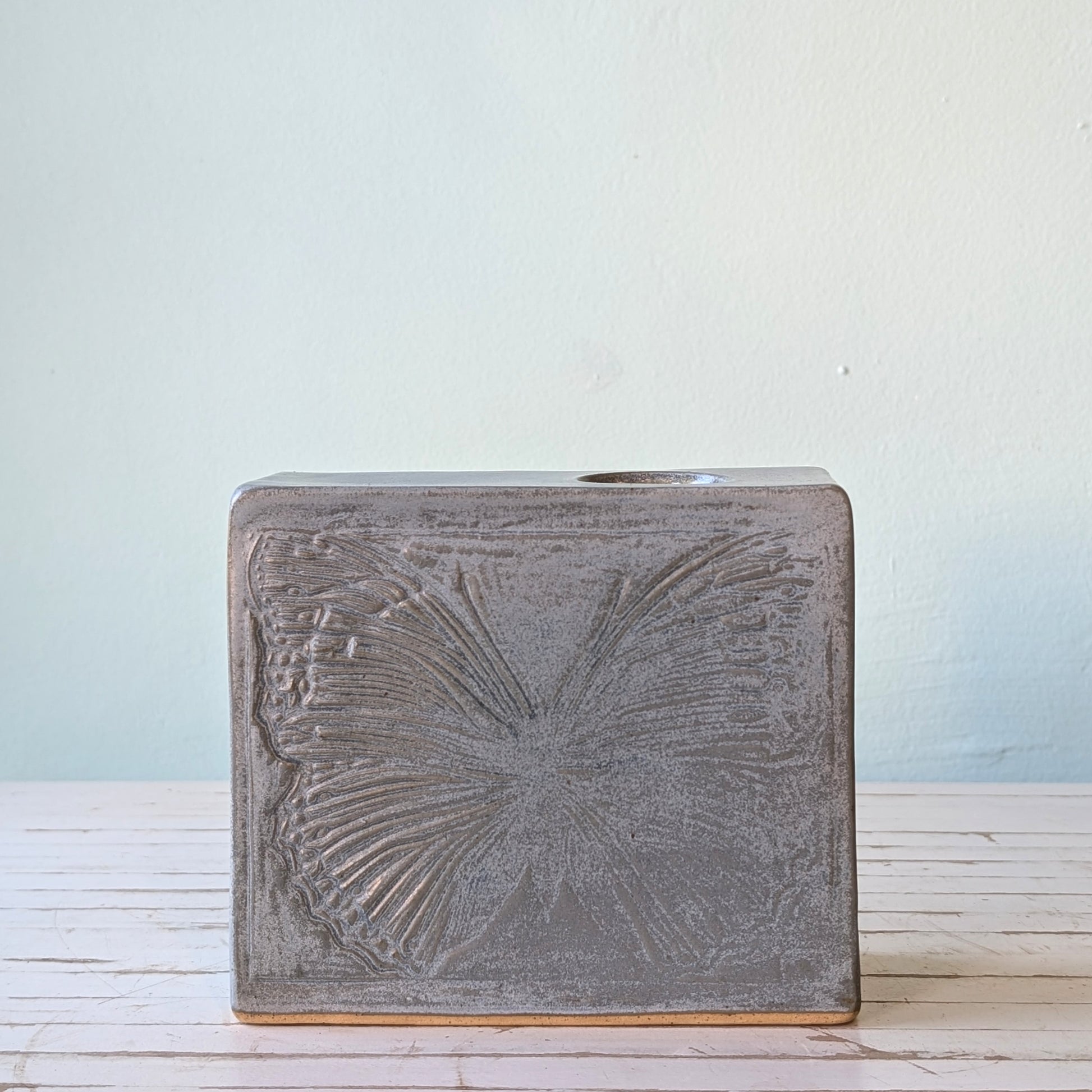 Front view of a grey/blue ceramic rectangular vase with a linocut butterfly pattern