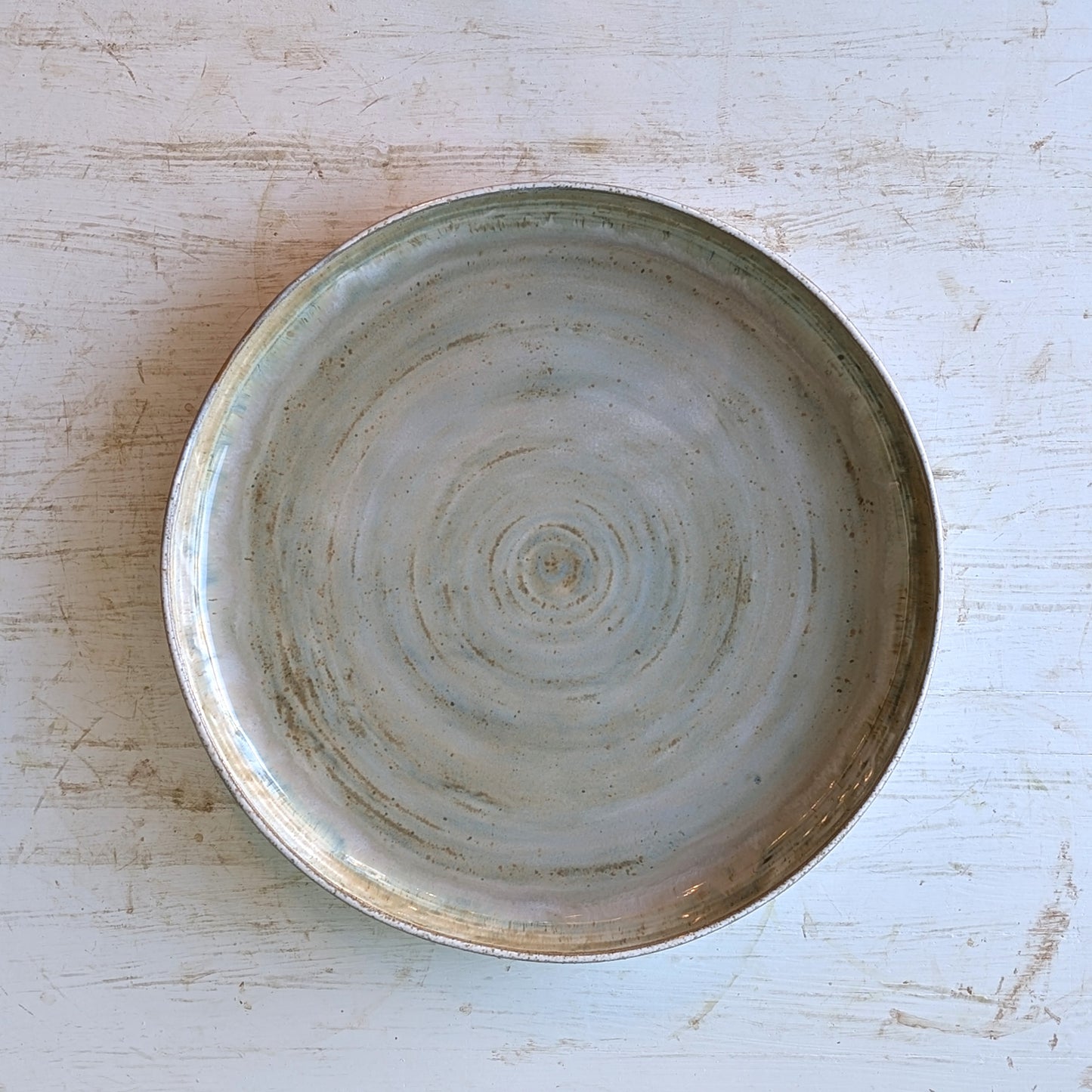 Ceramic bowl with concentric circle pattern on a light wooden surface