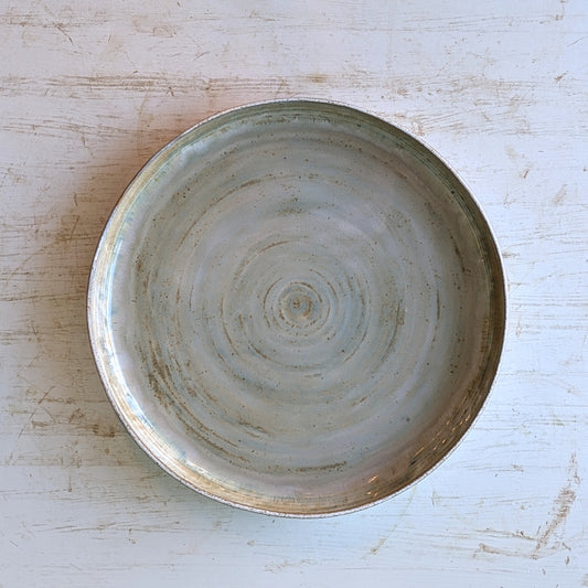 Ceramic bowl with concentric circle pattern on a light wooden surface