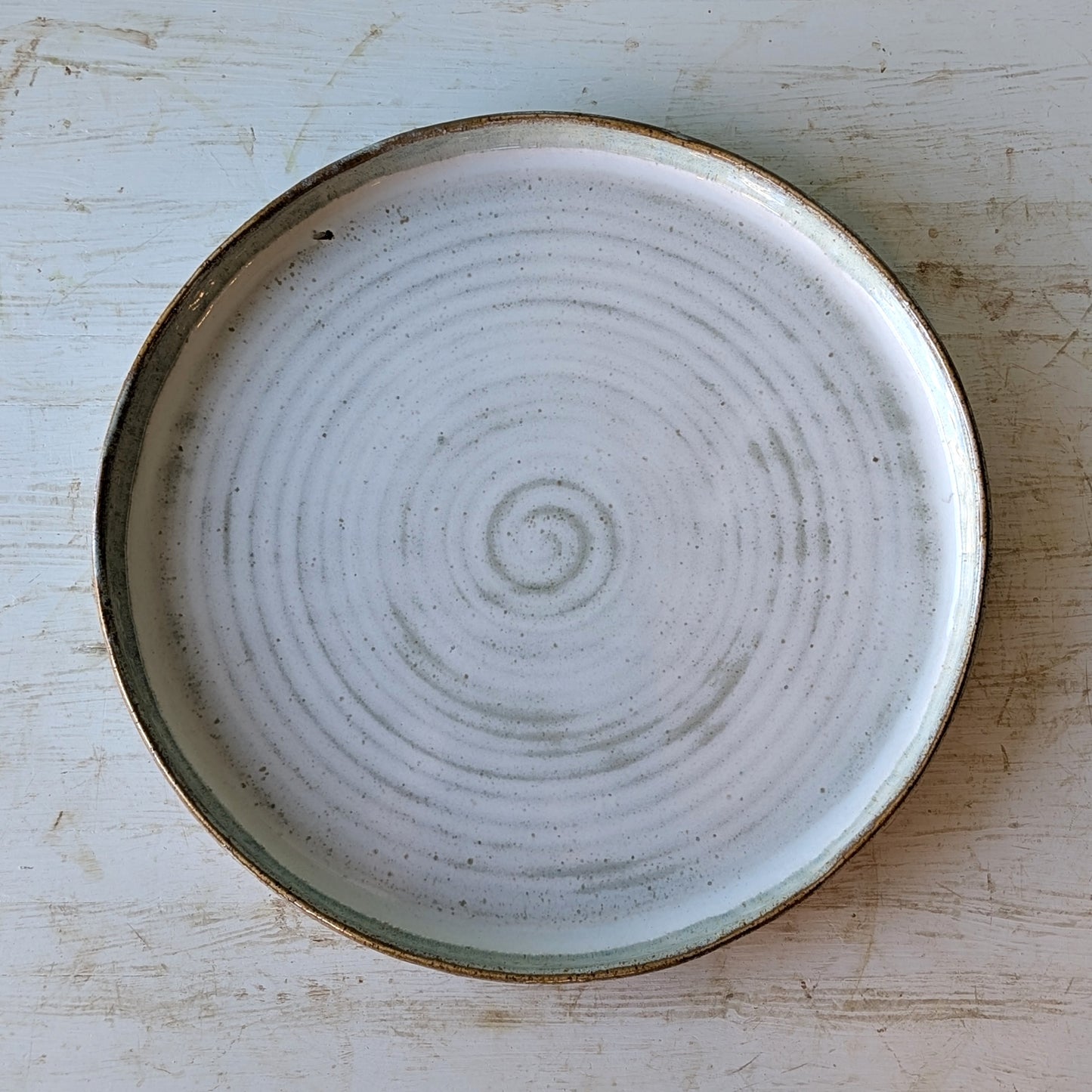 Ceramic plate with a spiral design on a wooden surface