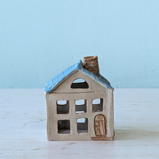 Small ceramic house figurine with blue roof