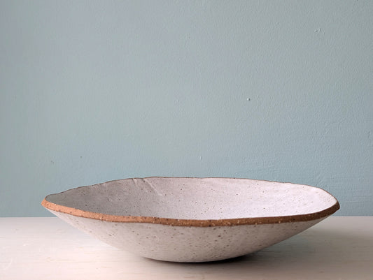 Ceramic bowl with a textured surface on a light blue background