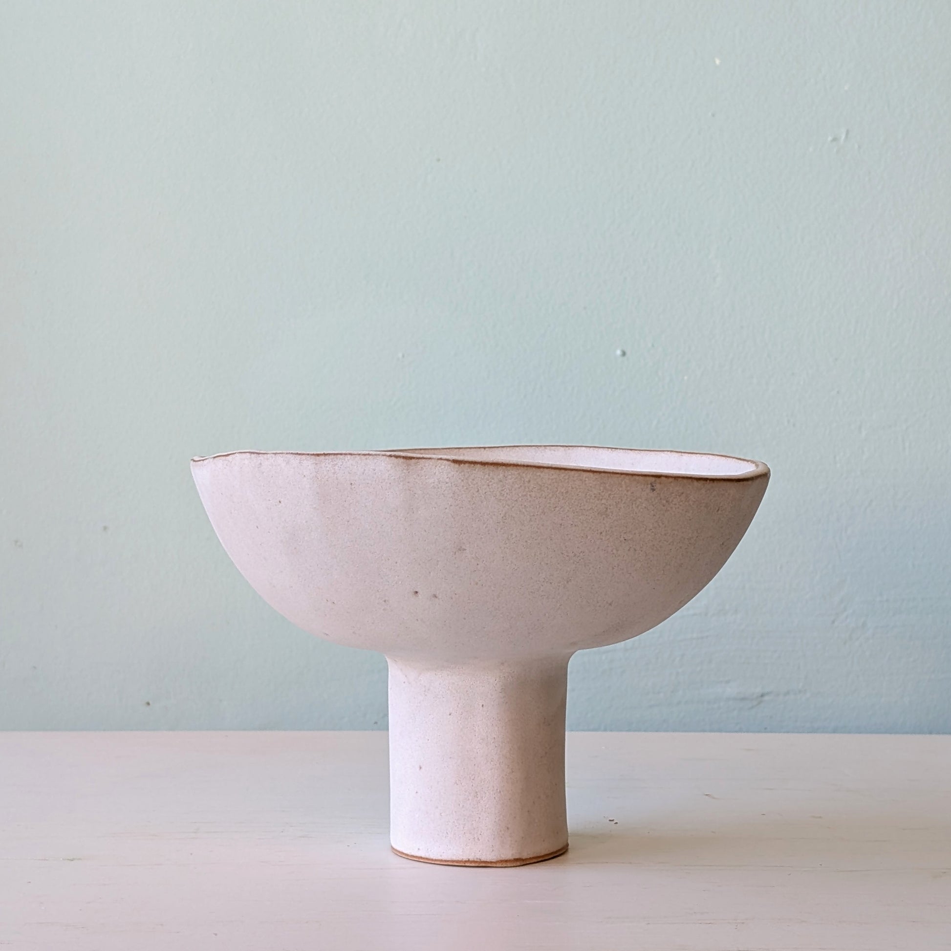 Ceramic bowl on a light surface with a light blue background