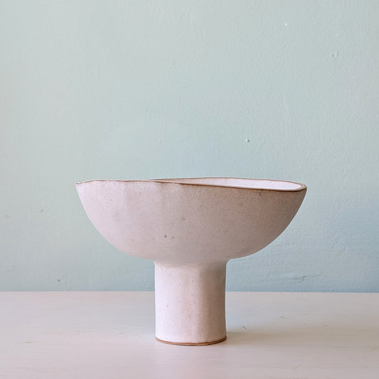 Ceramic bowl on a light surface with a light blue background
