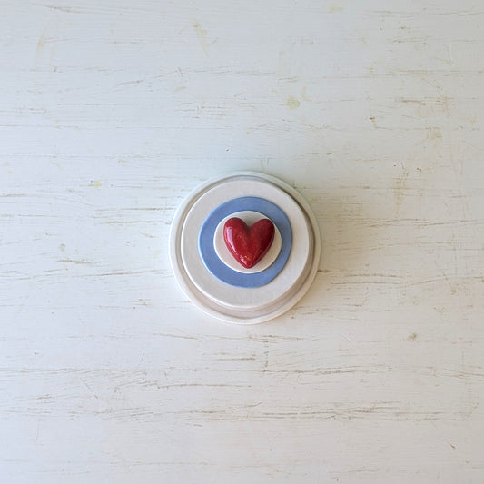 Round ceramic butter dish with a red heart on a white background