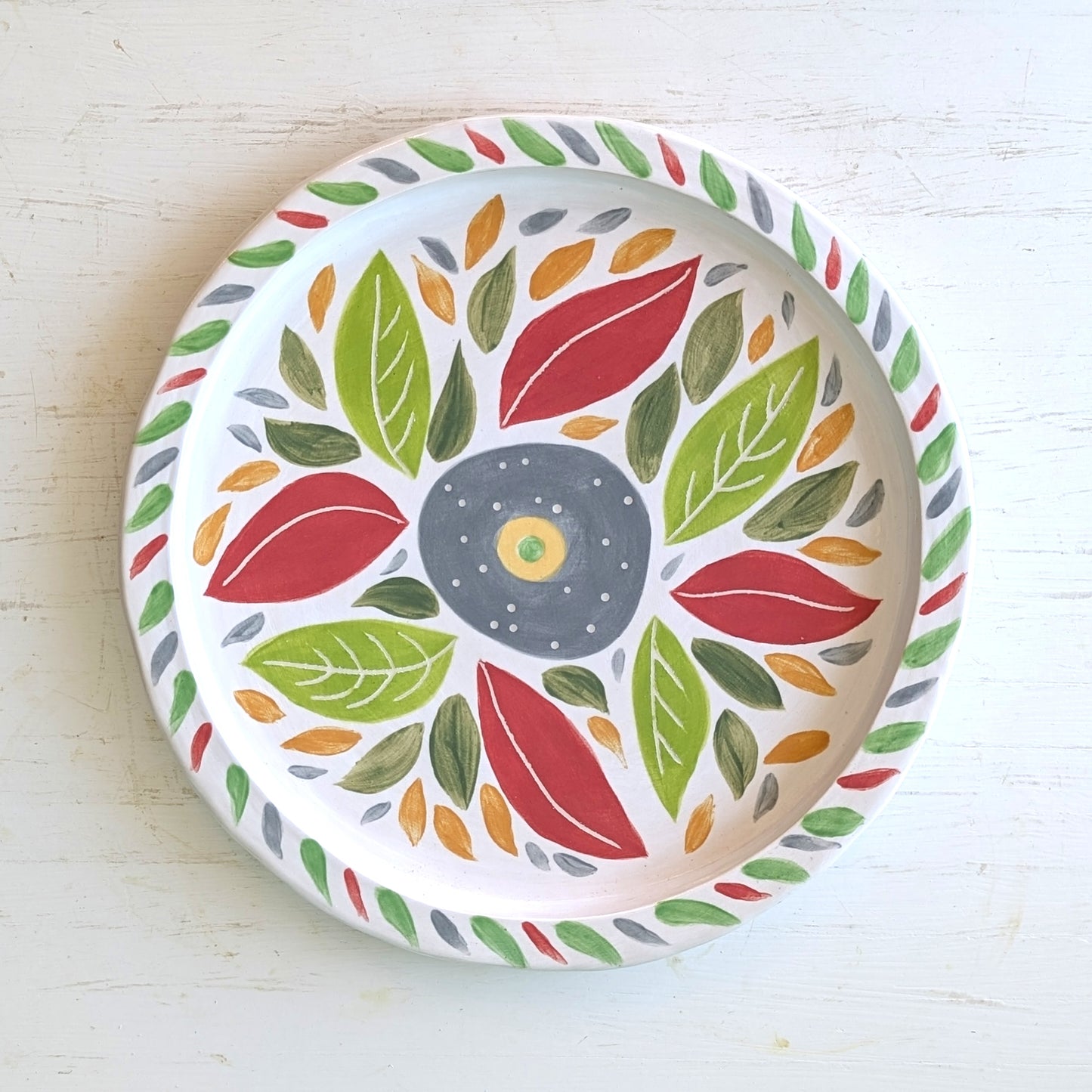 Decorative plate with colorful leaf pattern on a white background