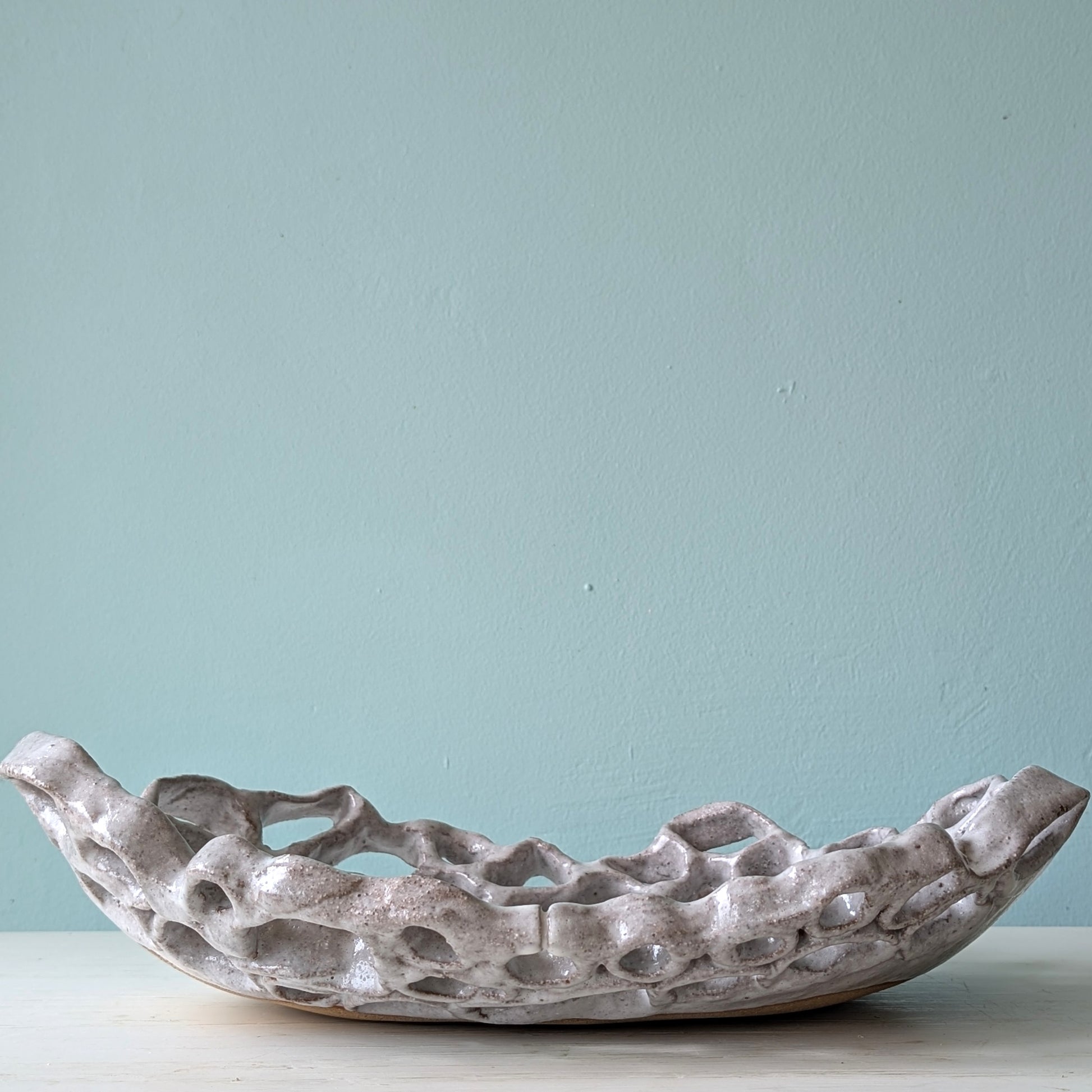 Decorative stoneware bowl on a light blue background