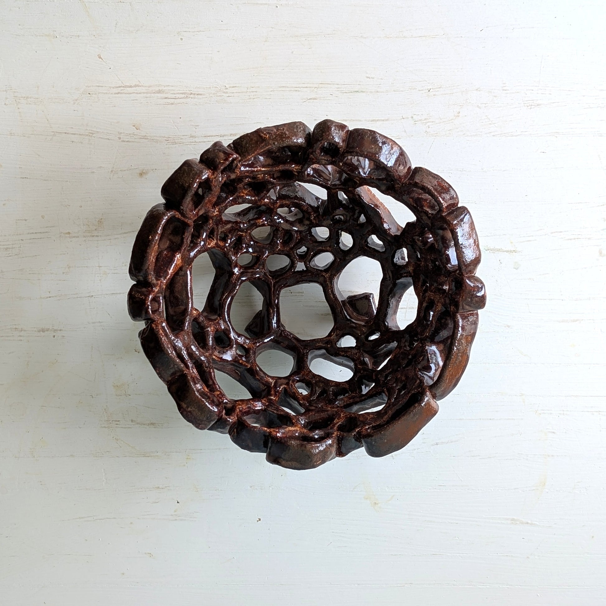 Decorative brown ceramic bowl on a light wooden surface
