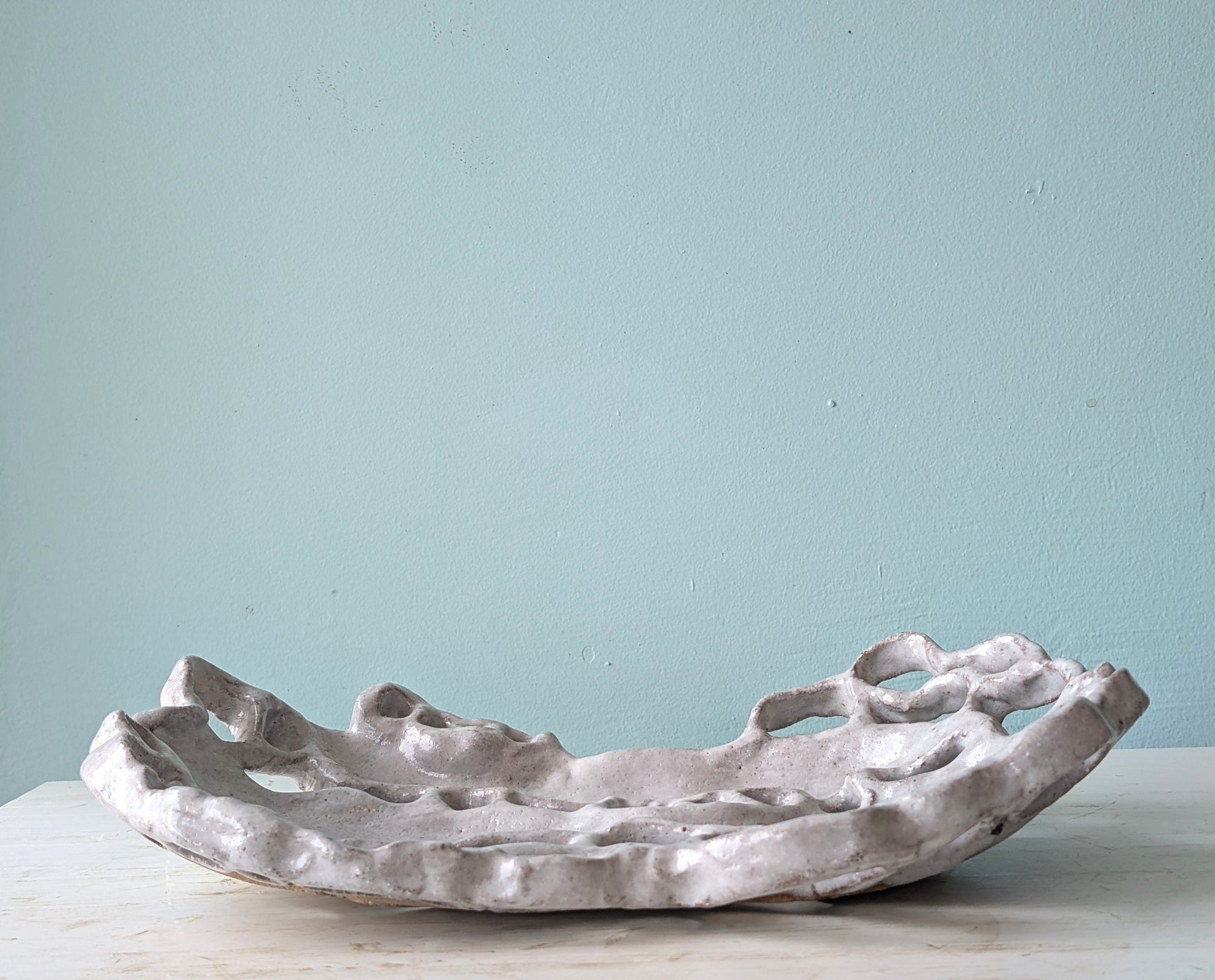 Decorative ceramic bowl on a light surface with a light blue background