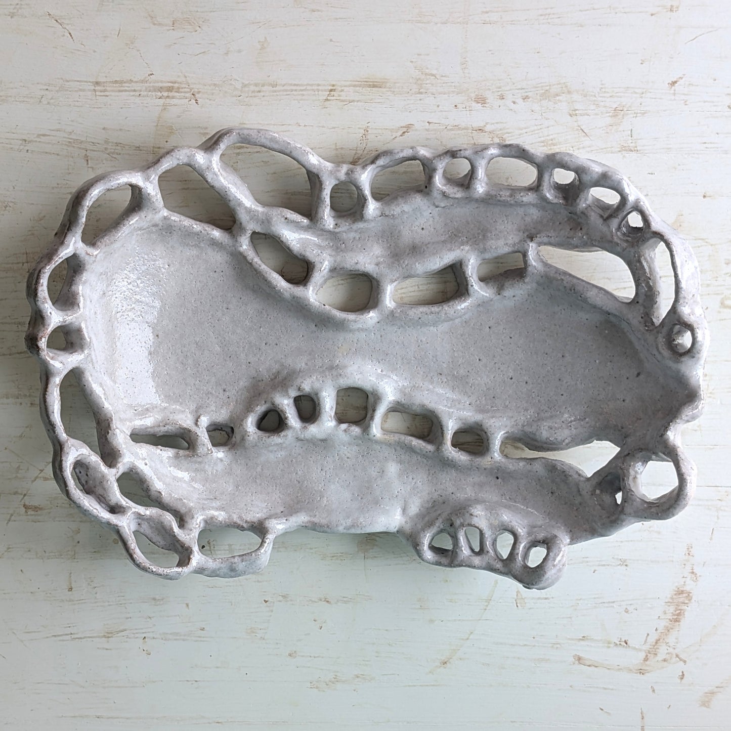 Decorative ceramic platter with intricate design on a light wooden surface
