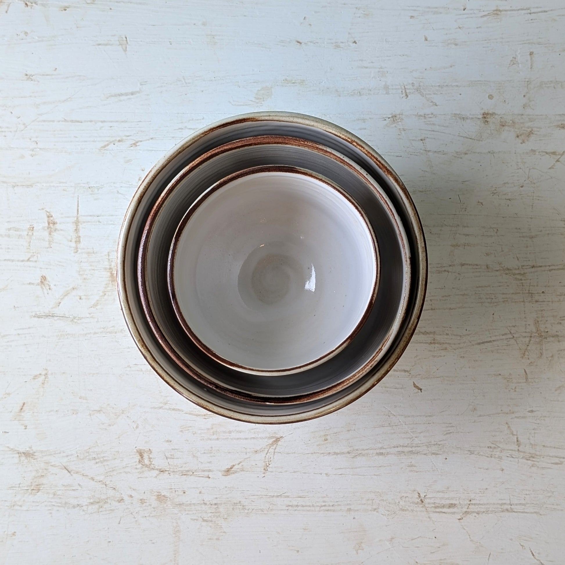 Stack of ceramic bowls on a textured white surface