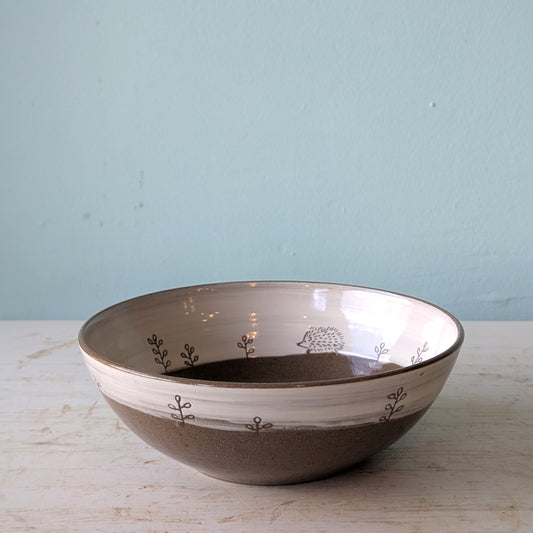 Ceramic bowl with decorative patterns on a light wooden surface and blue background