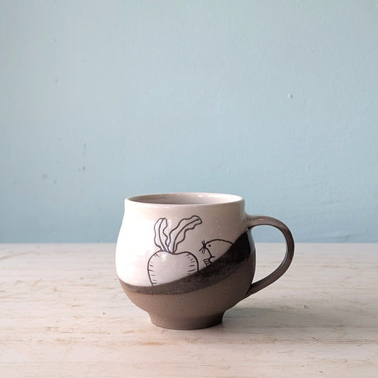 Ceramic mug with a handle on a wooden surface against a light blue background
